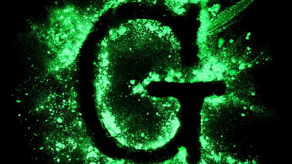 A green letter g on a black epoxy resin background.