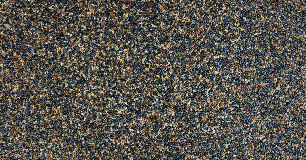 A close up image of a blue and brown carpet installed with epoxy flooring.