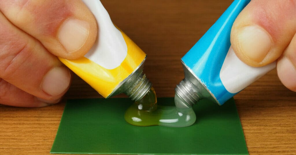 A person is applying epoxy resin on a piece of paper.